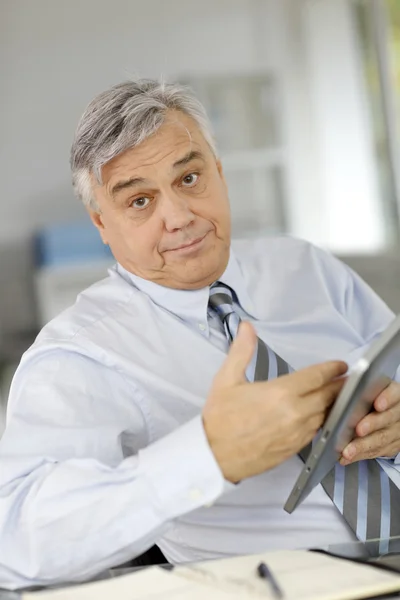 Senior-Geschäftsmann spricht mit Kunden und nutzt Tablet — Stockfoto