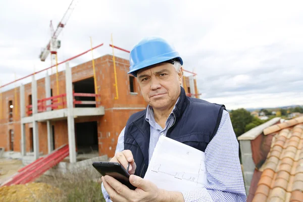 Empreendedor no local de construção usando smartphone — Fotografia de Stock