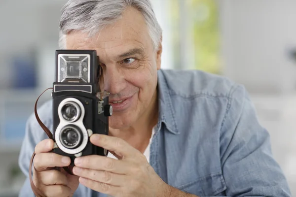 Senior photographer holding vintage camera — Stock Photo, Image