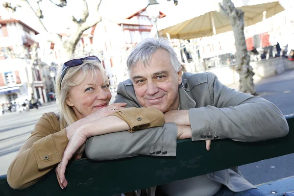 Senior koppel zittend op een bankje openbare — Stockfoto