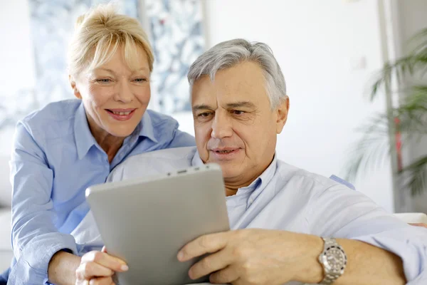 Moderna pareja de ancianos websurf en la tableta —  Fotos de Stock