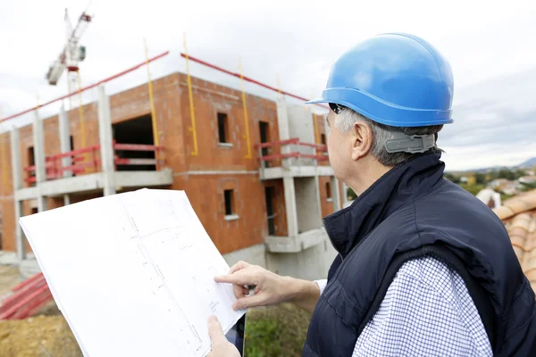 Gerente de construcción verificando proyecto de construcción en sitio —  Fotos de Stock