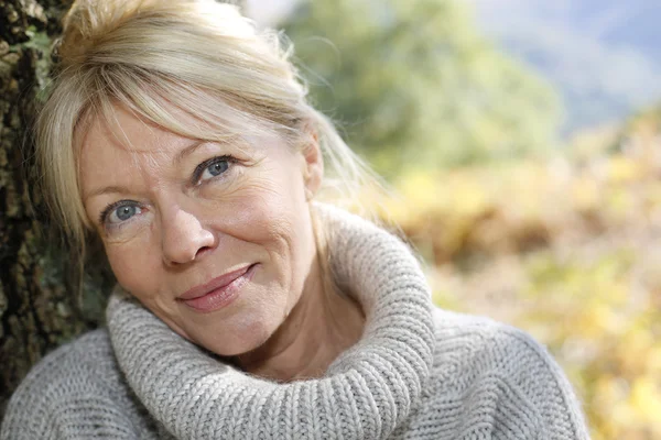 Portrait of senior woman leaning against tree — Stock Photo, Image