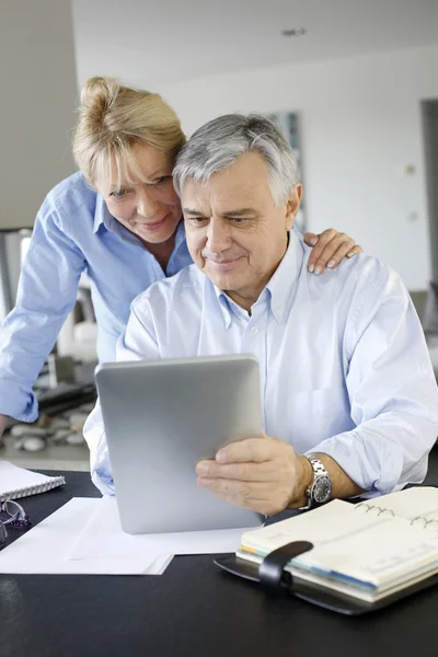 Pareja mayor mirando la cuenta bancaria en la tableta digital — Foto de Stock