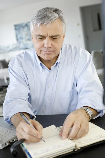 Senior zakenman die op laptop van thuiswerken — Stockfoto