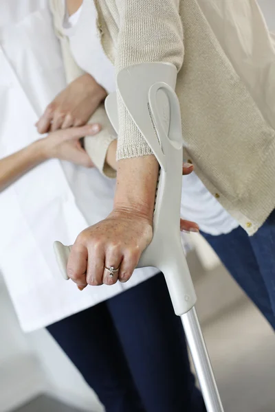 Nahaufnahme der auf Krücken gestützten Hände einer alten Frau — Stockfoto