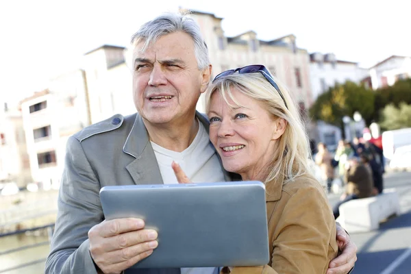 Starší pár pomocí digitálních tabletu v turistické oblasti — Stock fotografie