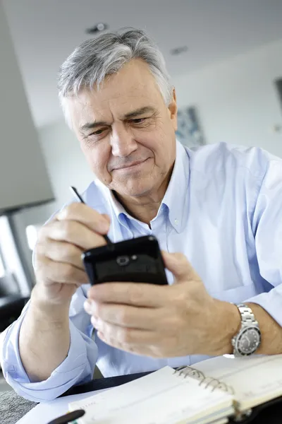 Portrét senior obchodník pomocí smartphone — Stock fotografie