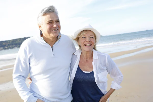 Seniorenpaar spaziert im Herbst am Strand — Stockfoto