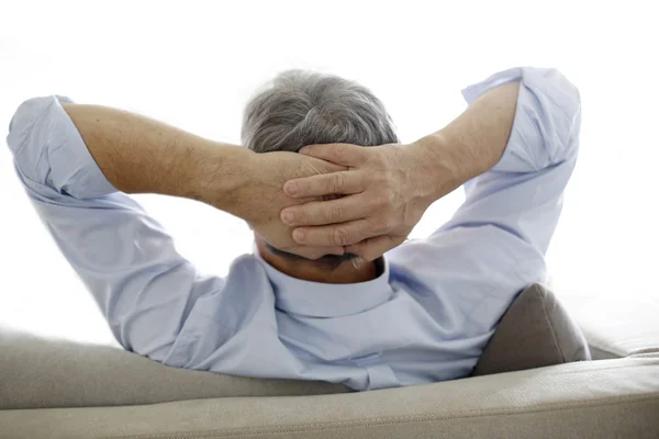 Visão traseira do homem velho relaxando no sofá — Fotografia de Stock