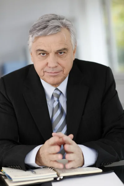 Portret van senior zakenman zit aan Bureau — Stockfoto