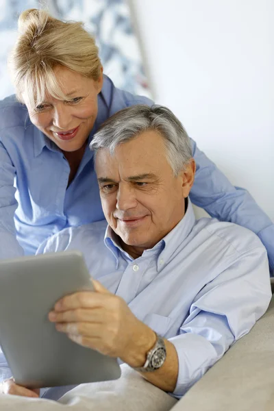 Modern senior couple websurfing on tablet — Stock Photo, Image