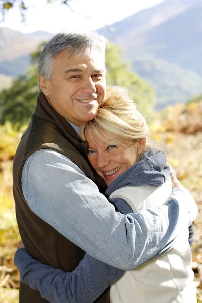 Idősebb pár vidéken mosolyogva portréja — Stock Fotó