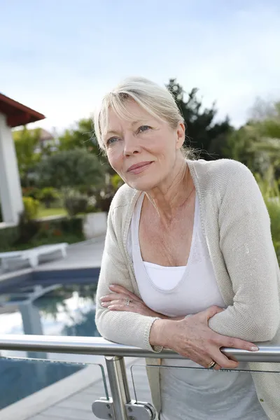 Portret van senior vrouw permanent voorzijde woning — Stockfoto