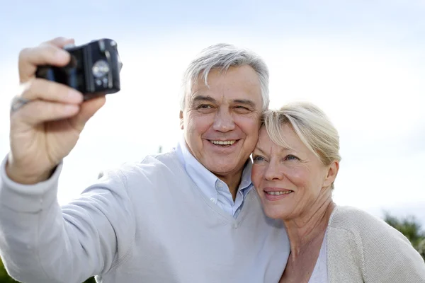 Casal sênior tirando fotos de si mesmos fora — Fotografia de Stock