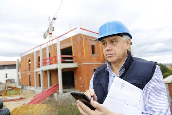 Girişimci smartphone kullanarak inşaat sitesinde — Stok fotoğraf