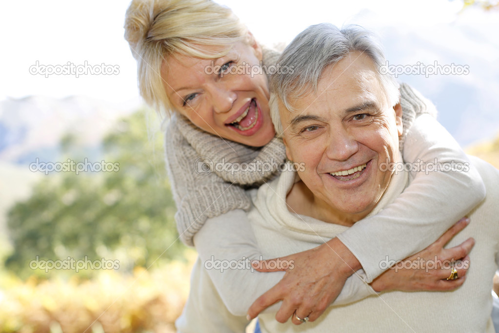 Senior man giving piggyback ride to wife