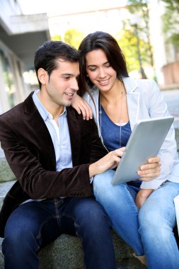 Genç çift websurfing şehirdeki tablet ile internet üzerinde
