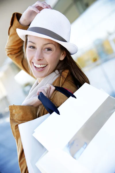 Menina alegre na cidade segurando sacos de compras — Fotografia de Stock