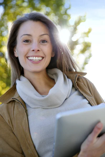 Красивая девушка с помощью цифрового планшета снаружи — стоковое фото