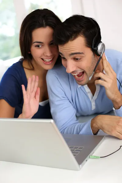 Cheerful young couple chating on internet with webcamera — Stock Photo, Image