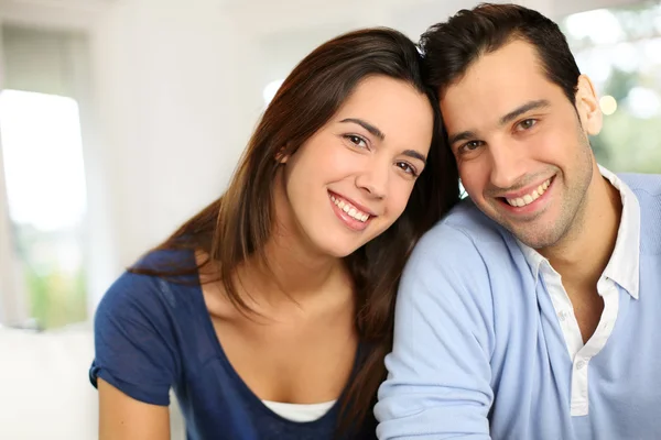 Retrato de una linda pareja joven sentada en un sofá — Foto de Stock