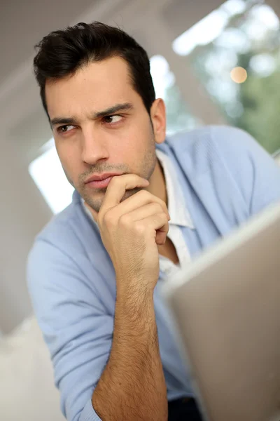 Puzzled young man using digital tablet — Stock Photo, Image