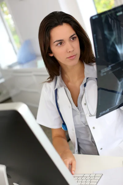 Mujer médica joven comprobando los resultados de rayos X —  Fotos de Stock