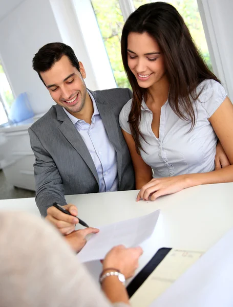 Junges Paar unterschreibt Finanzvertrag — Stockfoto