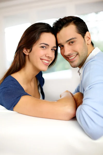 Portrait of cute young couple sitting in sofa — Stock Photo, Image