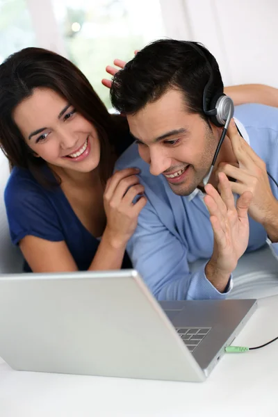 Веселая молодая пара болтает в Интернете с веб-камерой — стоковое фото