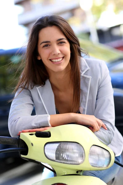 Genç kadın binicilik scooter şehirdeki gülümseyen — Stok fotoğraf