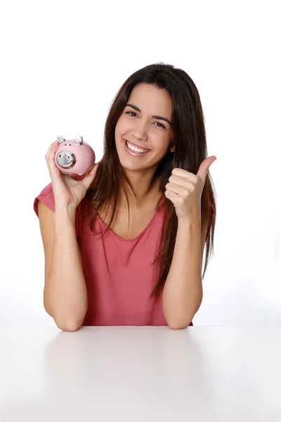 Meisje holding piggy bank en weergegeven: duim omhoog — Stockfoto