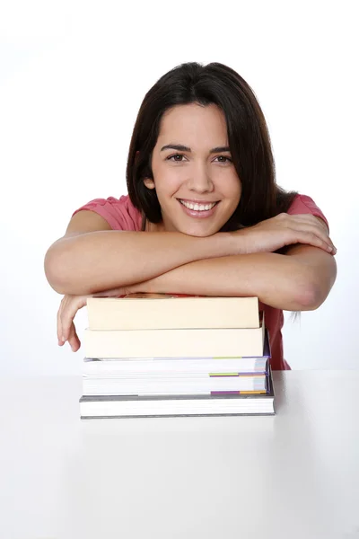 Portrait of cheerful student girl leaning on pile of books — Stock Photo, Image