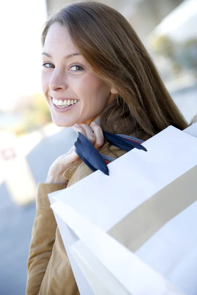 Cheerful girl in town holding shopping bags Stock Photo