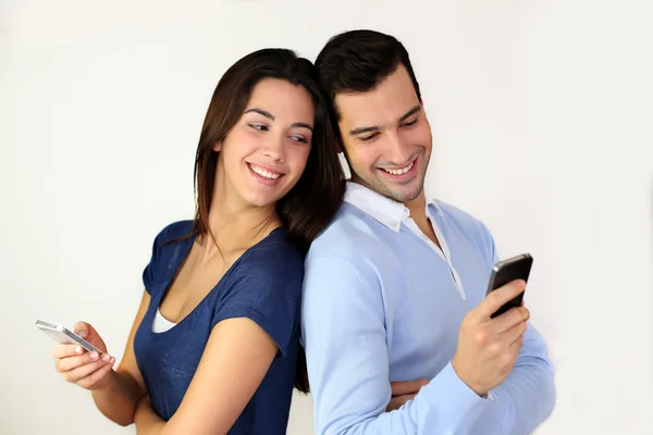 Couple standing back to back and using smartphone — Stock Photo, Image