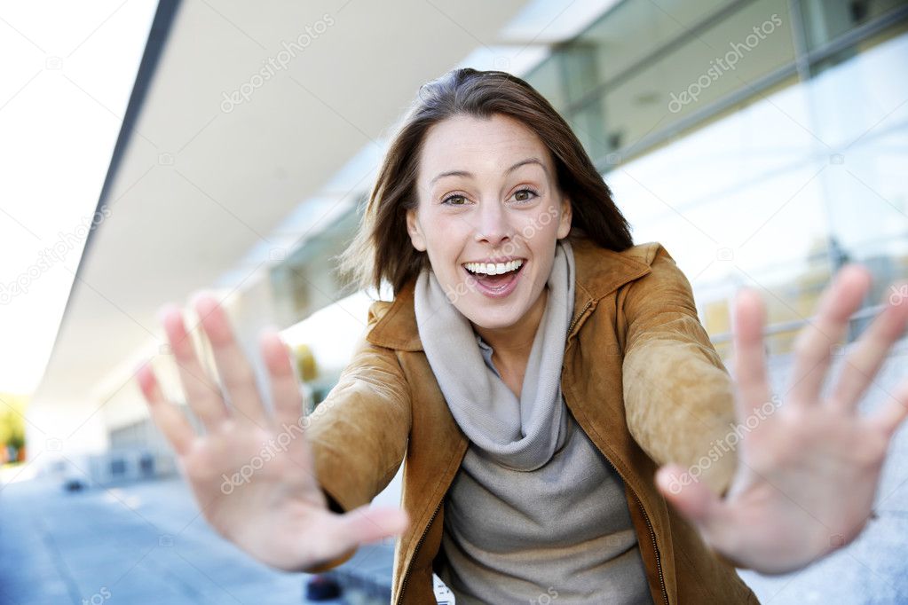 Cheerful girl showing hands towards camera