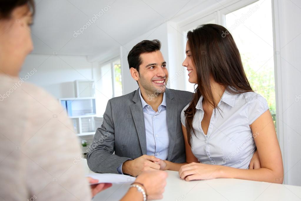 Young couple signing financial contract