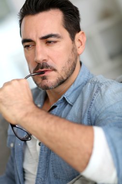 kanepe düşünceli yüzündeki ile oturan adam