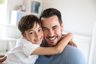 Portrait of father and son relaxing at home clipart