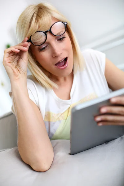 Lustiges Mädchen vor Tablet mit überraschtem Blick — Stockfoto