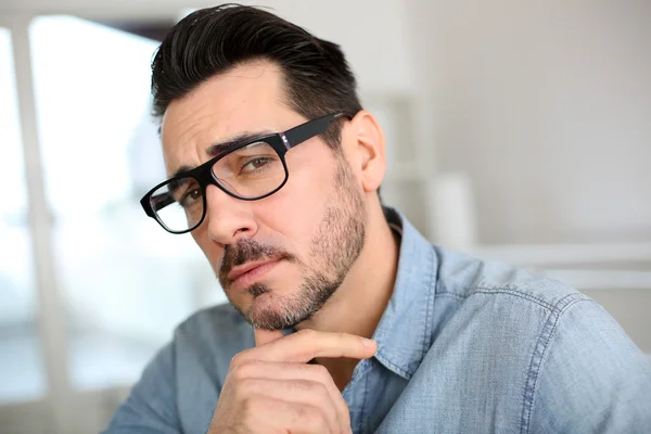 Trendy man with hand on chin looking at camera — Stock Photo, Image