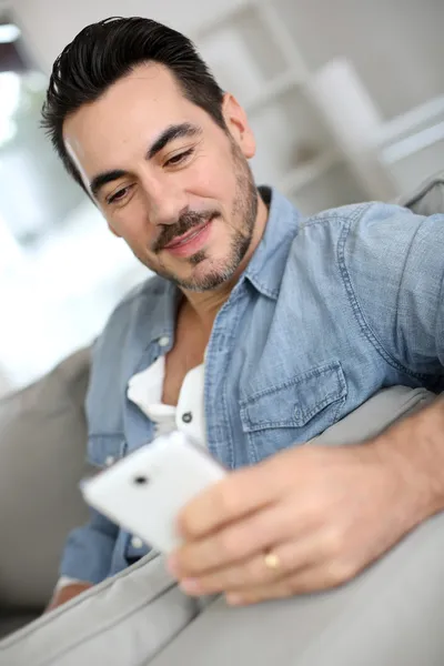 Homme d'âge moyen souriant utilisant un smartphone — Photo