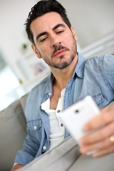 Hombre serio de mediana edad usando un teléfono inteligente — Foto de Stock