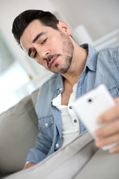 Hombre serio de mediana edad usando un teléfono inteligente — Foto de Stock