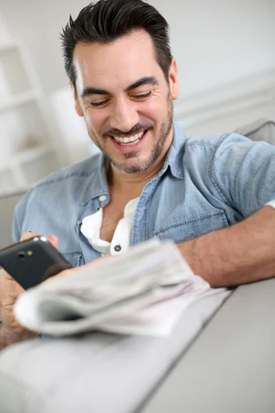 Hombre relajándose en casa con periódico — Foto de Stock