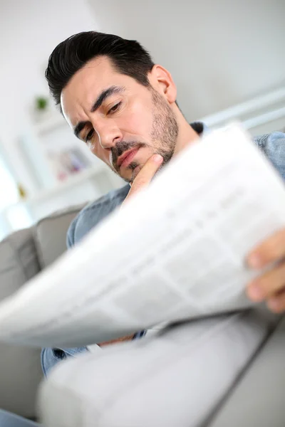 Mann liest zu Hause schlechte Nachrichten in Zeitung — Stockfoto