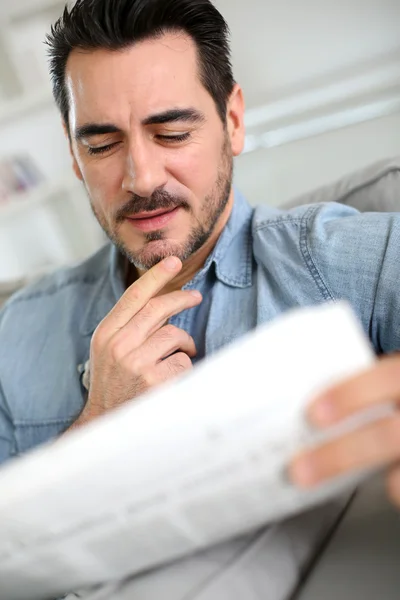 Homem lendo jornal com olhar atento — Fotografia de Stock