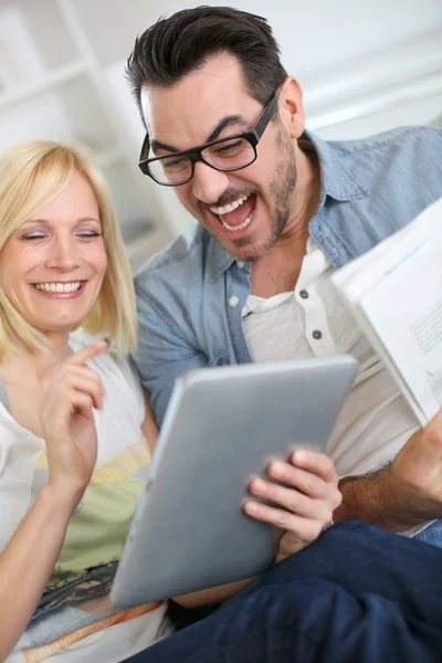 Couple reading news on both internet and paper — Stock Photo, Image