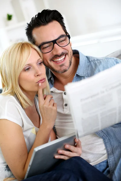 Casal em casa lendo notícias — Fotografia de Stock